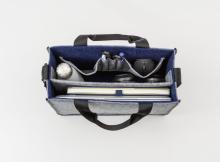 Offene Tasche mit Laptop, Wasserflasche, Kopfhörer und Stiften