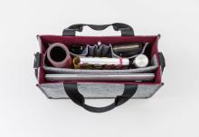 Geöffnete Tasche mit Laptop, Notizbuch, Stift und Becher