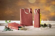 Red gift bags on table, with book and decoration