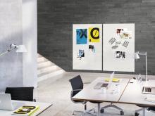 Modern office environment with tables, laptops and two whiteboards on the wall