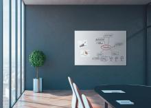 Whiteboard with diagrams in modern conference room, next to plant