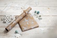 Wrapping paper with winter pattern on wooden background, snowflakes and decorative balls