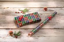 Gift in patterned paper and roll on wooden table Fir branch and decoration by the way