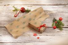 Wrapping paper with Christmas print and wrapped gift, red ribbon