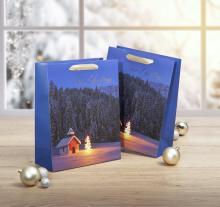 Blue gift bags with Christmas motif, next to baubles