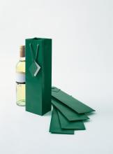 Green gift bag next to wine bottle