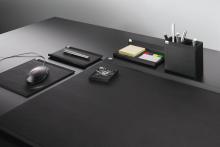 Black desk with accessories office supplies neatly placed