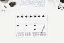 Weekly planner with calendar, keyboard, mouse and pen on white table