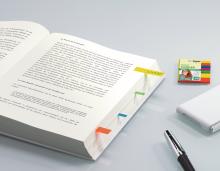 Open book with markers, pen next to it