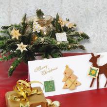 Weihnachtsgesteck mit Kerze und Karten