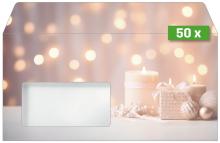 Candles, gift box and baubles against blurred glowing background