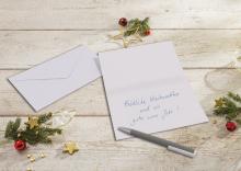 Christmas card with lettering surrounded by fir branches and decoration