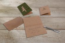 Christmas Cards and Envelopes on Wooden Table Card with Handwritten Greeting: Merry Christmas and a Happy New Year!