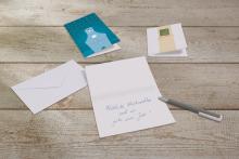 Christmas cards and envelopes on wooden table
