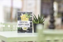 Cocktail advertising and plant on table
