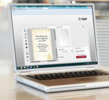 Laptop shows graphics software with Christmas card