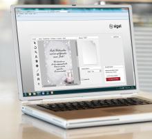 Laptop showing design software with Christmas card, text and tools