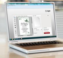 Laptop with open design program, Christmas card is being designed