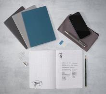 Notebook with drawings and text, next to stationery