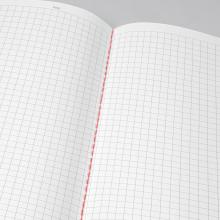 Open notebook with squared paper and red thread