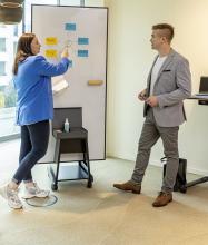 People discussing on a whiteboard