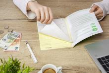 Hand blättert Papier, Euros, Laptop