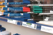 Colorful pens and pencils in sales containers, with price tags underneath
