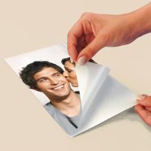 Paper is peeled from portrait of a smiling person