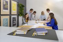 Gruppe im Meeting am Tisch, lächelnd