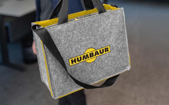 Die graue Businesstasche aus Filz zeigt ein Logo der Firma Humbaur