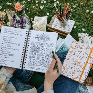Frau zeichnet in Jolie Notizbüchern
