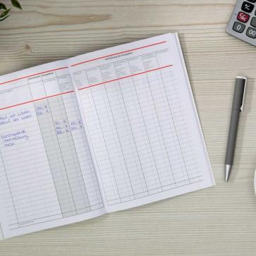 Offenes Haushaltsbuch mit Notizen und Kugelschreiber