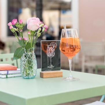Blumenstrauß, Notizbücher und Aperol auf Tisch